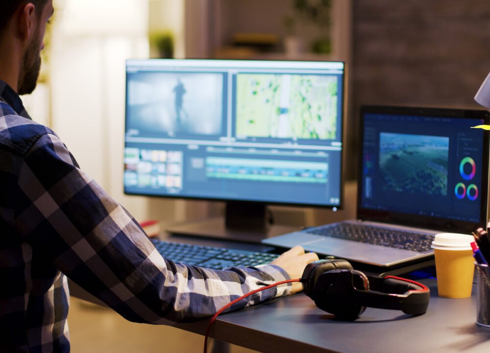 Movie maker editing a film using modern software for post production. Young videographer. Home office.